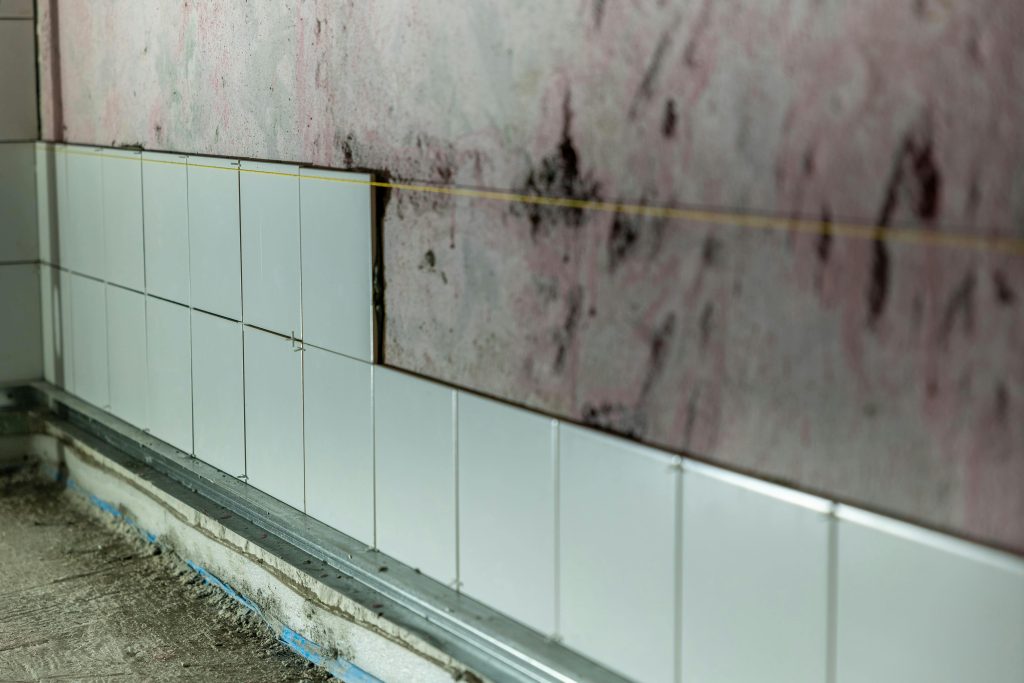 pexels-photo-29181495-29181495 Close-up of partially tiled wall in a construction area, showcasing incomplete renovation work.